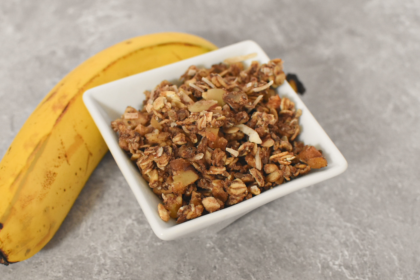 Sourdough discard banana bread in a bowl near a banana