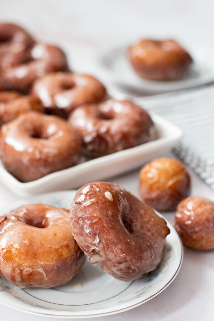 fluffy yeasted potato donuts with maple vanilla glaze on a plate