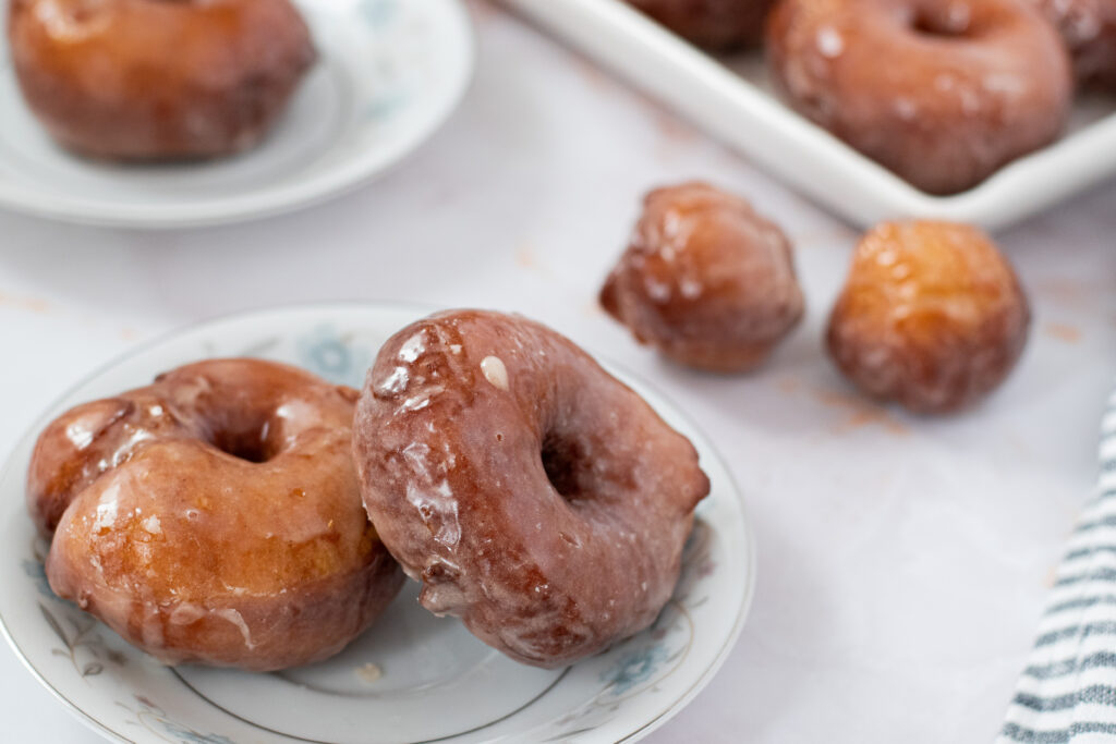 fluffy yeasted potato donuts with maple vanilla glaze on a plate