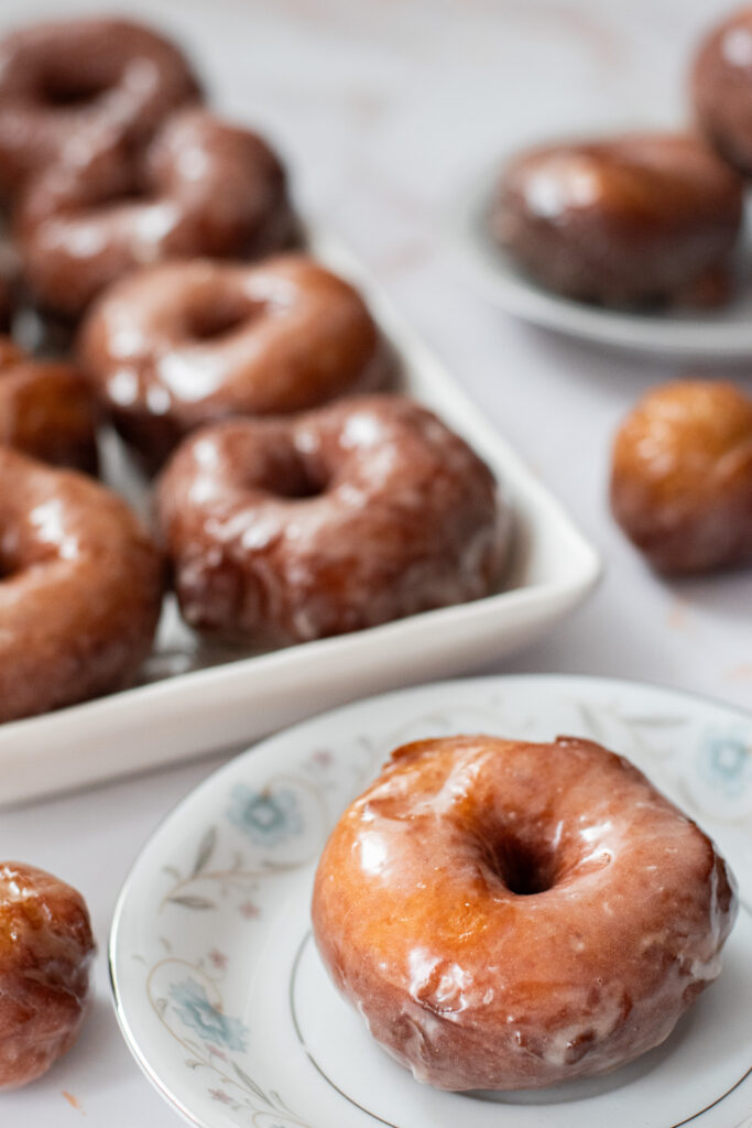 fluffy yeasted potato donuts with maple vanilla glaze on a plate