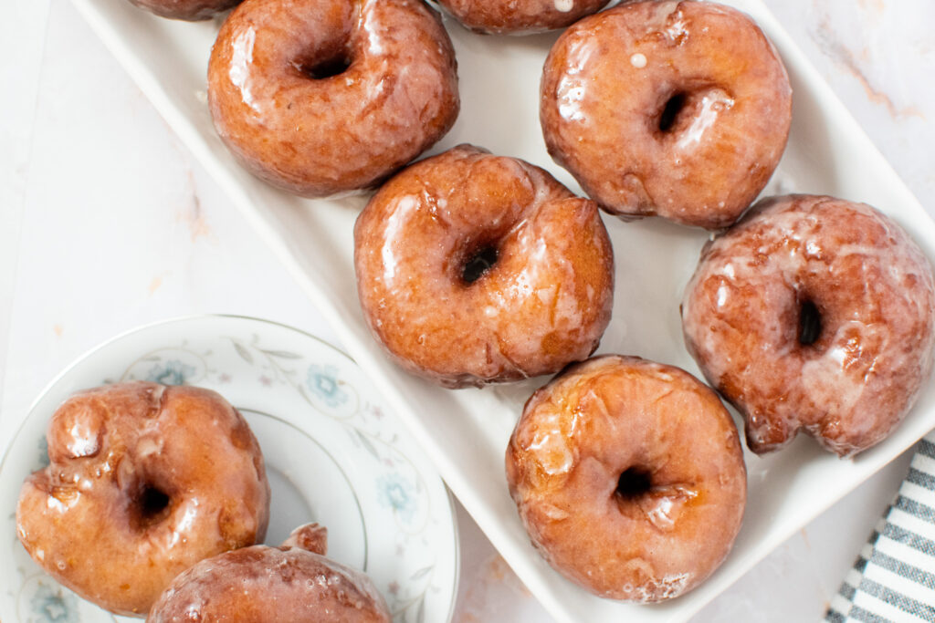 fluffy yeasted potato donuts with maple vanilla glaze on a plate