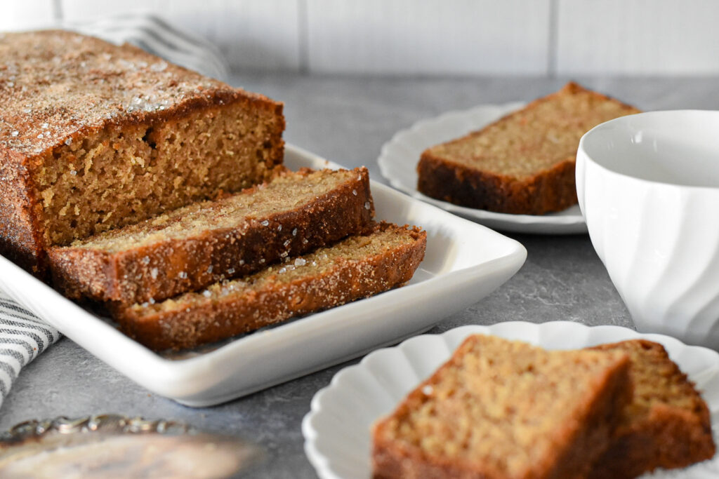 Close-up of a moist apple cider loaf cake slice, showing fluffy layers infused with spiced apple cider flavors.