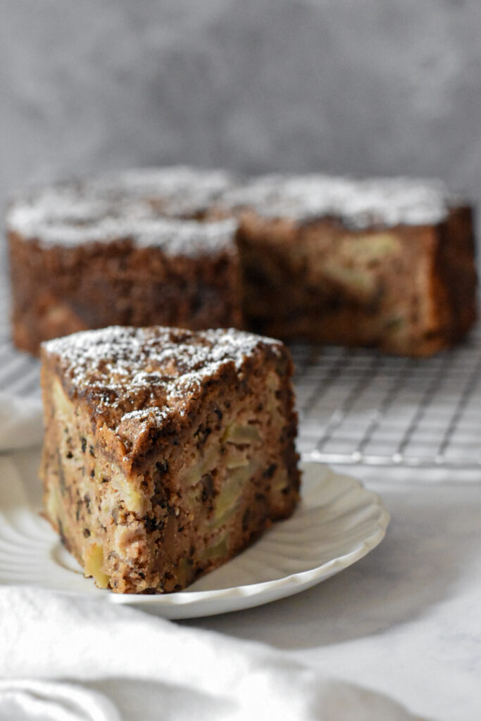 Tender and moist apple spice snacking cake on a cooling rack, slice of tender apple spice cake