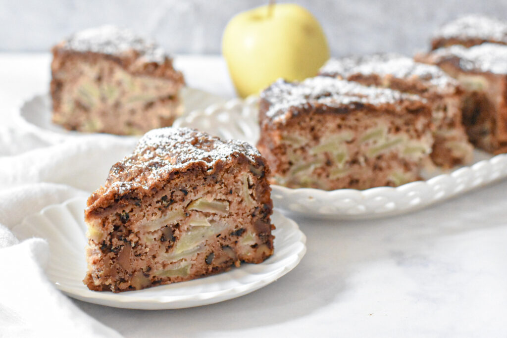 Tender and moist apple spice snacking cake on a cooling rack, slice of tender apple spice cake