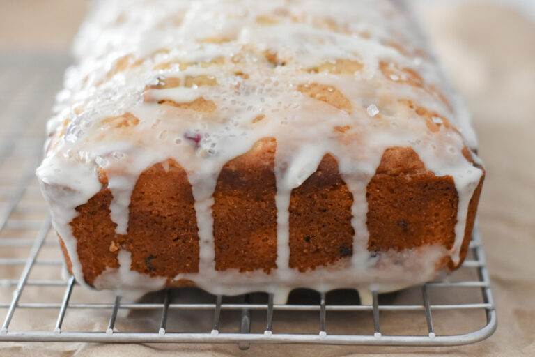 cranberry bread loaf with citrus glaze on a plate