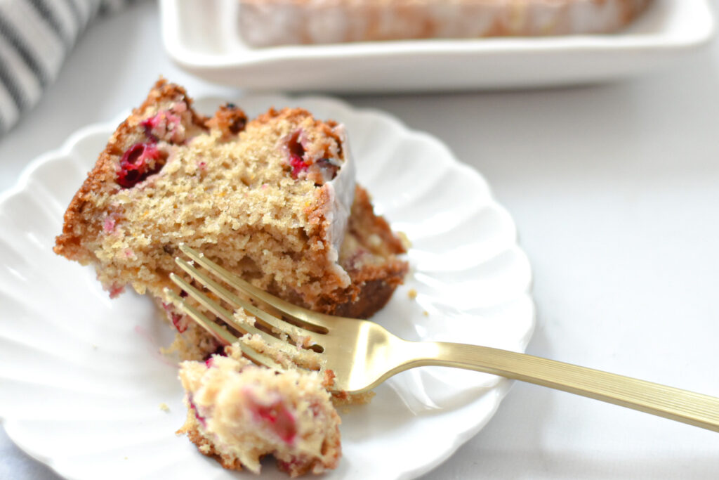 cranberry orange bread with citrus glaze on a plate