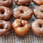 fluffy yeast raised potato donuts on a cooling rack