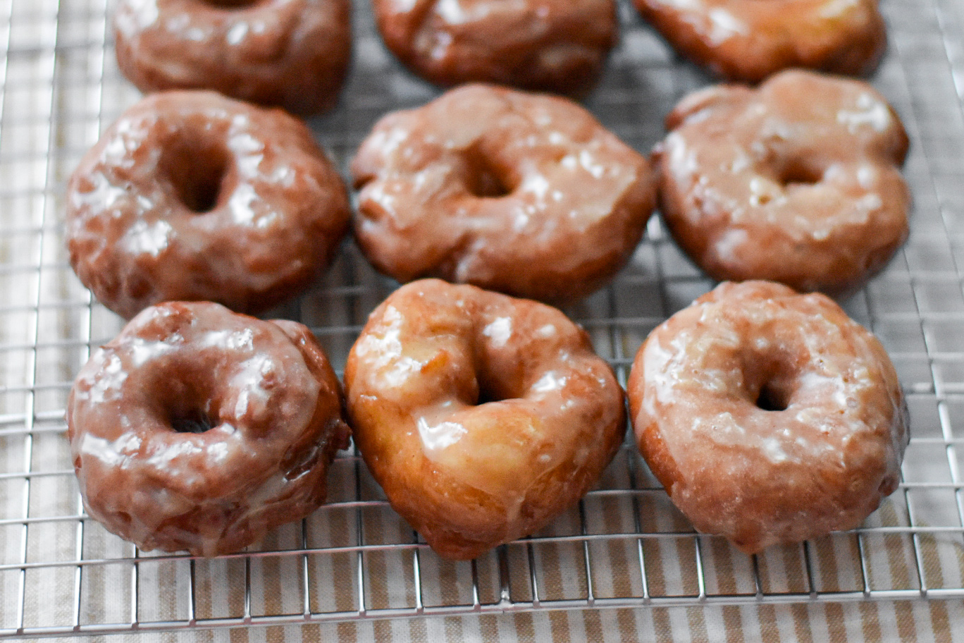 fluffy yeast raised potato donuts on a cooling rack